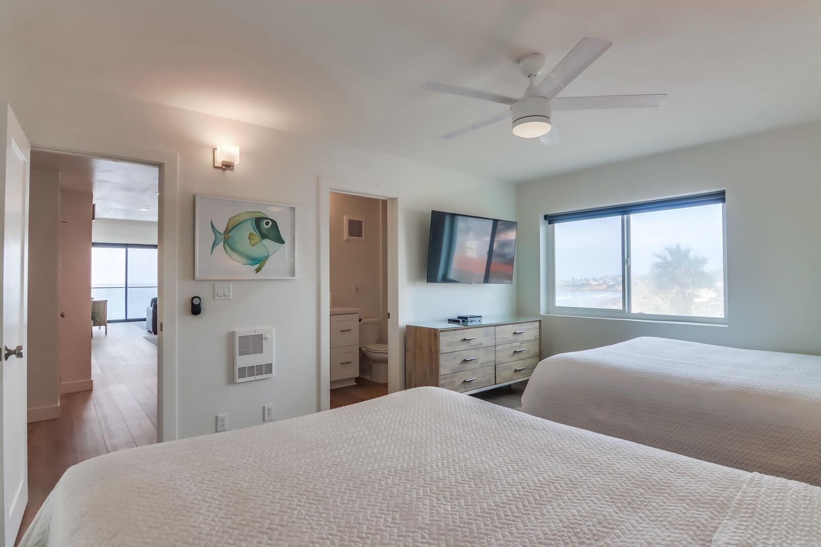Guest bedroom with overhead light/fan, large, smart TV and in-suite bathroom