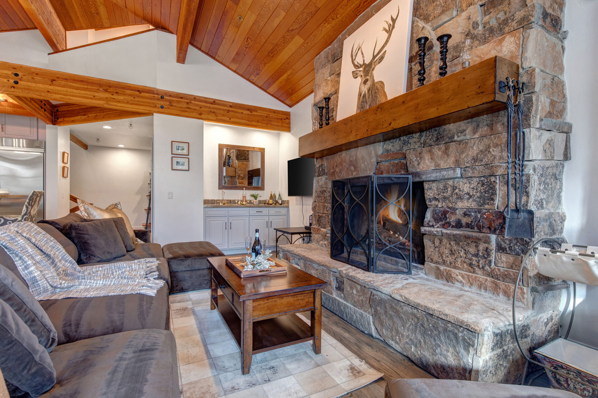 Living Room with gas-assist fireplace, plush over-sized sectional, wet bar, Samsung smart TV, vaulted ceilings, and deck access overlooking the Deer Valley Slopes