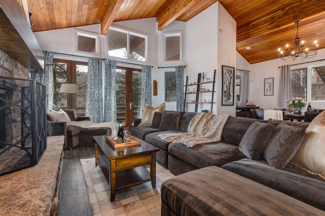 Living Room with gas-assist fireplace, plush over-sized sectional, wet bar, Samsung smart TV, vaulted ceilings, and deck access overlooking the Deer Valley Slopes