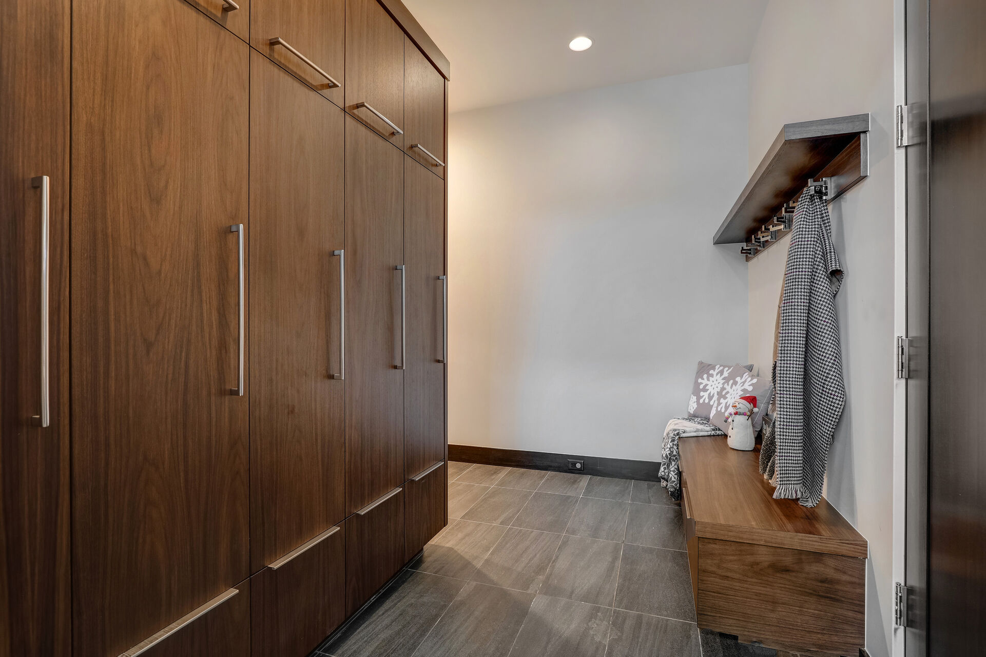Garage Entryway Mud Room with convenient bench, coat hooks, and equipment lockers