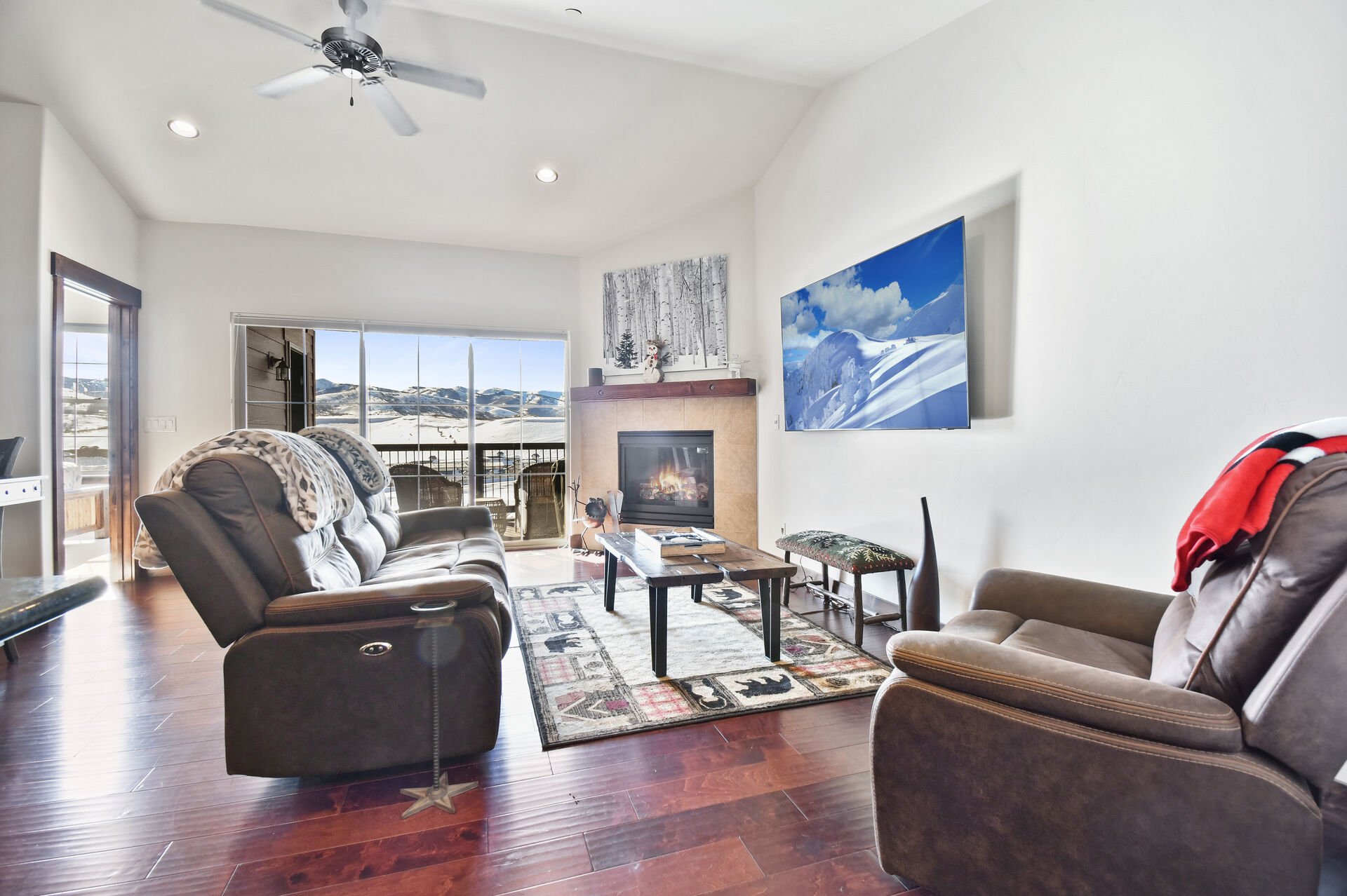 Living room with large HDTV and fireplace, overlooking the Park City mountain range.