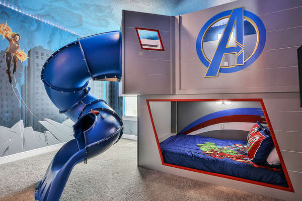 Kids are sure to enjoy this superhero-themed bedroom with a double/double bunk bed and tube slide
