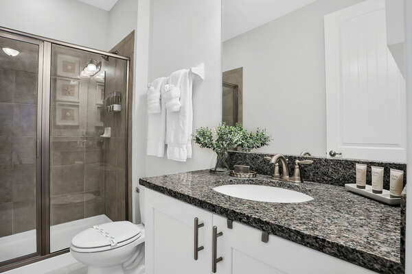 This full bathroom with a shower is located steps from the upstairs bedroom with a king-sized bed