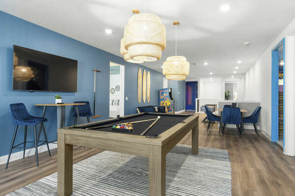 Upstairs, you'll find the loft with a pool table, foosball table, shuffleboard, multi-game arcade, and 65-inch TV