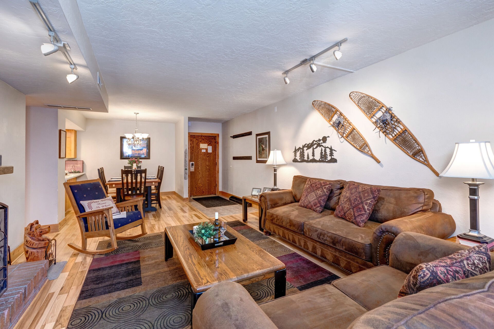 Living Room with gorgeous suede furnishings, sofa bed, wood-burning fireplace, Samsung smart TV, and private balcony access