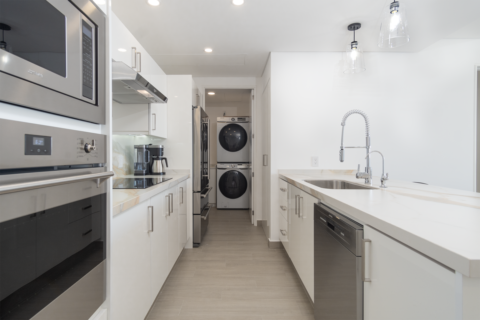 the kitchen has contemporary appliances and a washer and dryer