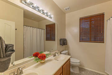 Bathroom 2 with new floors, dual sinks and a tub-shower combo is shared by Bedrooms 2 and 3.