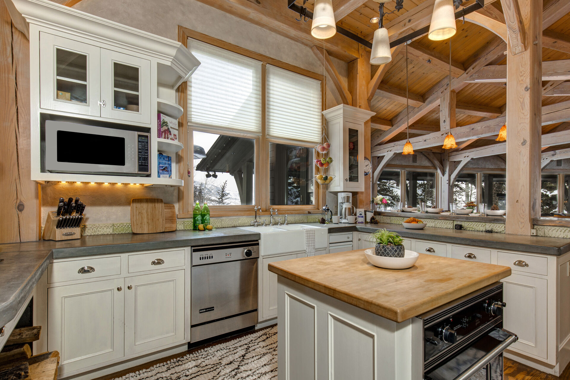 Gourmet Kitchen with Viking appliances, modern stone countertops, butcher block center island, wood burning fireplace, and additional prep kitchenette with private entrance and secondary appliances