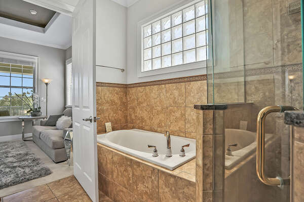 The second-floor master suite features a bathroom with shower and separate tub.