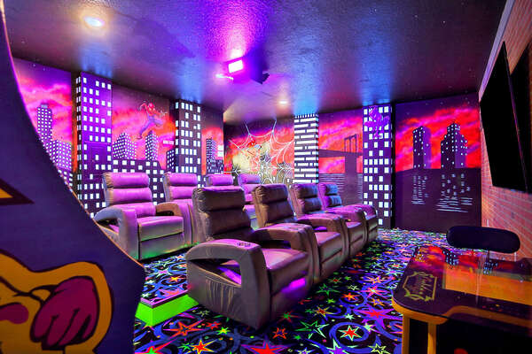 Fun awaits in the combined theater and game room with superhero theming.