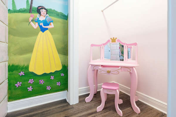 The princess-themed bedroom features a fun little vanity set