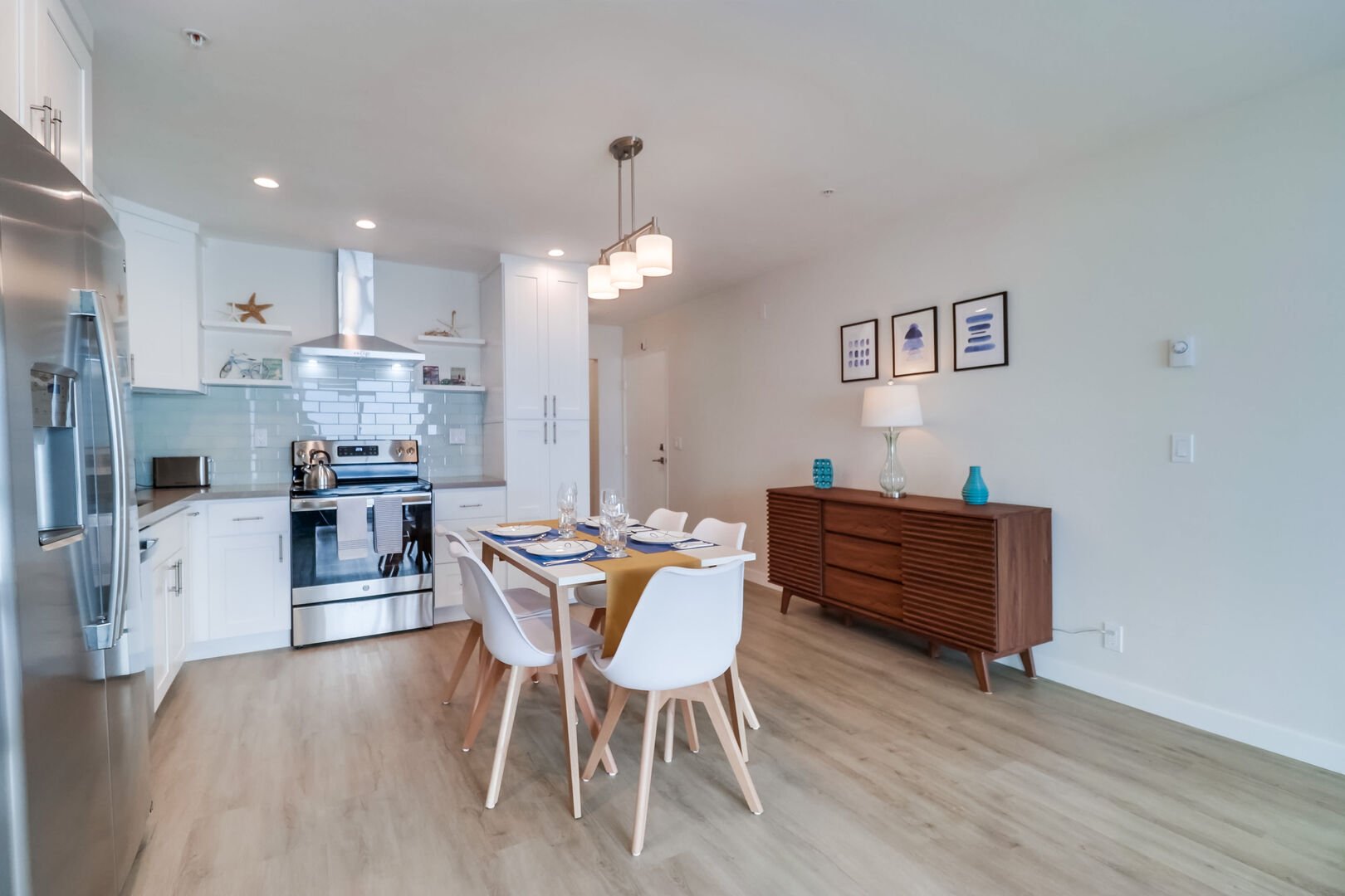 Open-style kitchen with modern, minimalist decor, stainless steel appliances and dining for 5 guests