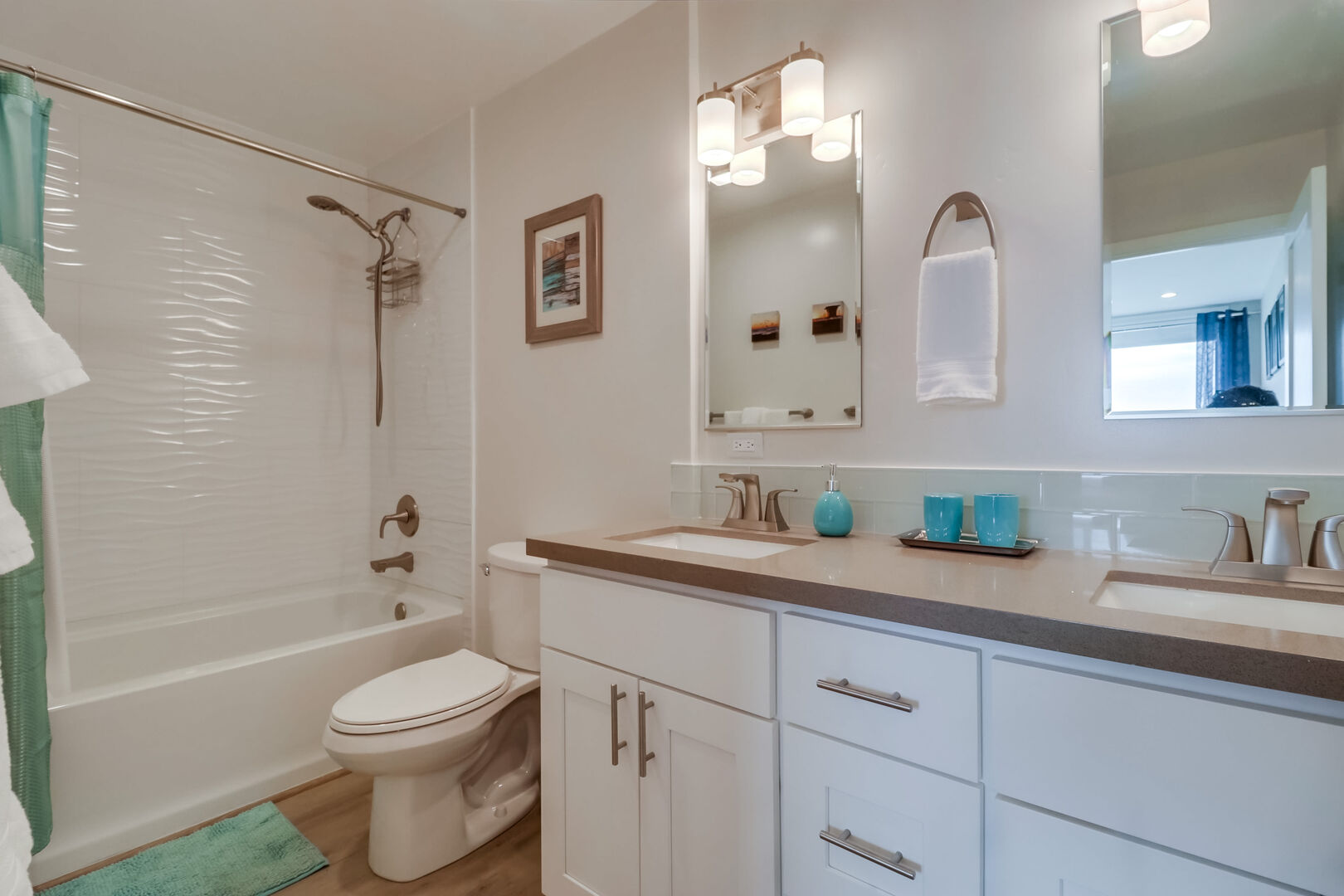 Master in-suite bathroom with dual vanity, ample storage space, toilet and tub/shower combo