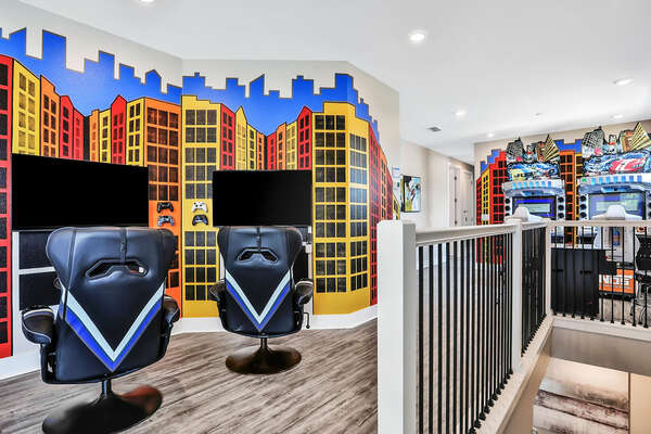 The loft arcade features a dual TV Xbox and PS4 with gaming chairs, a multi-arcade cocktail table, and dual Dead Heat racers