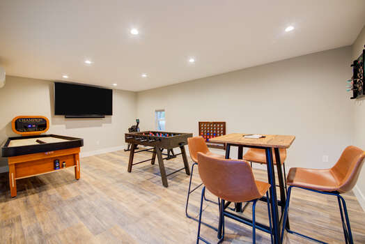 Game Room - Fitness Room.  Bank shuffle board, foosball table, digital dart board, Concept II rowing machine, 4-seat highboy table, connect 4, and 65