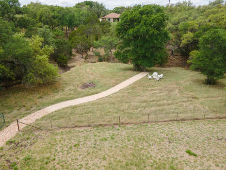 Beyond the putting green is a lovely trail leading the back of the property with a sun table and seasonal creek.