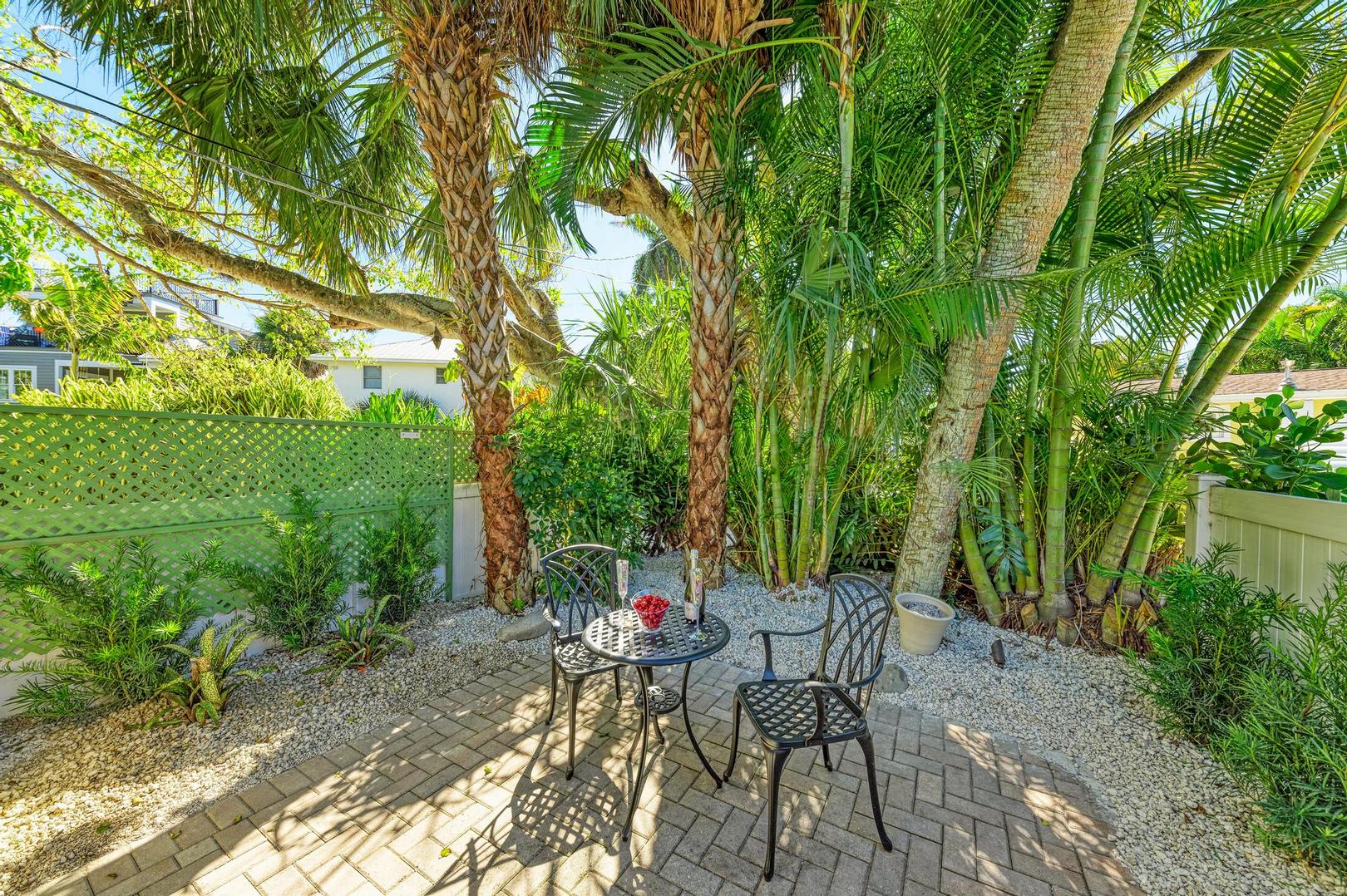 Turtle Tyme paver patio with bistro table and two chairs under trees