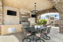 Fully equipped outdoor kitchen complete with a BBQ, cooktop and fridge and TV