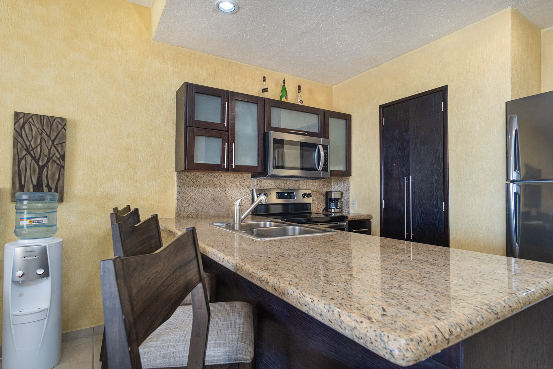 A counter top and bar stool seats define the kitchen.