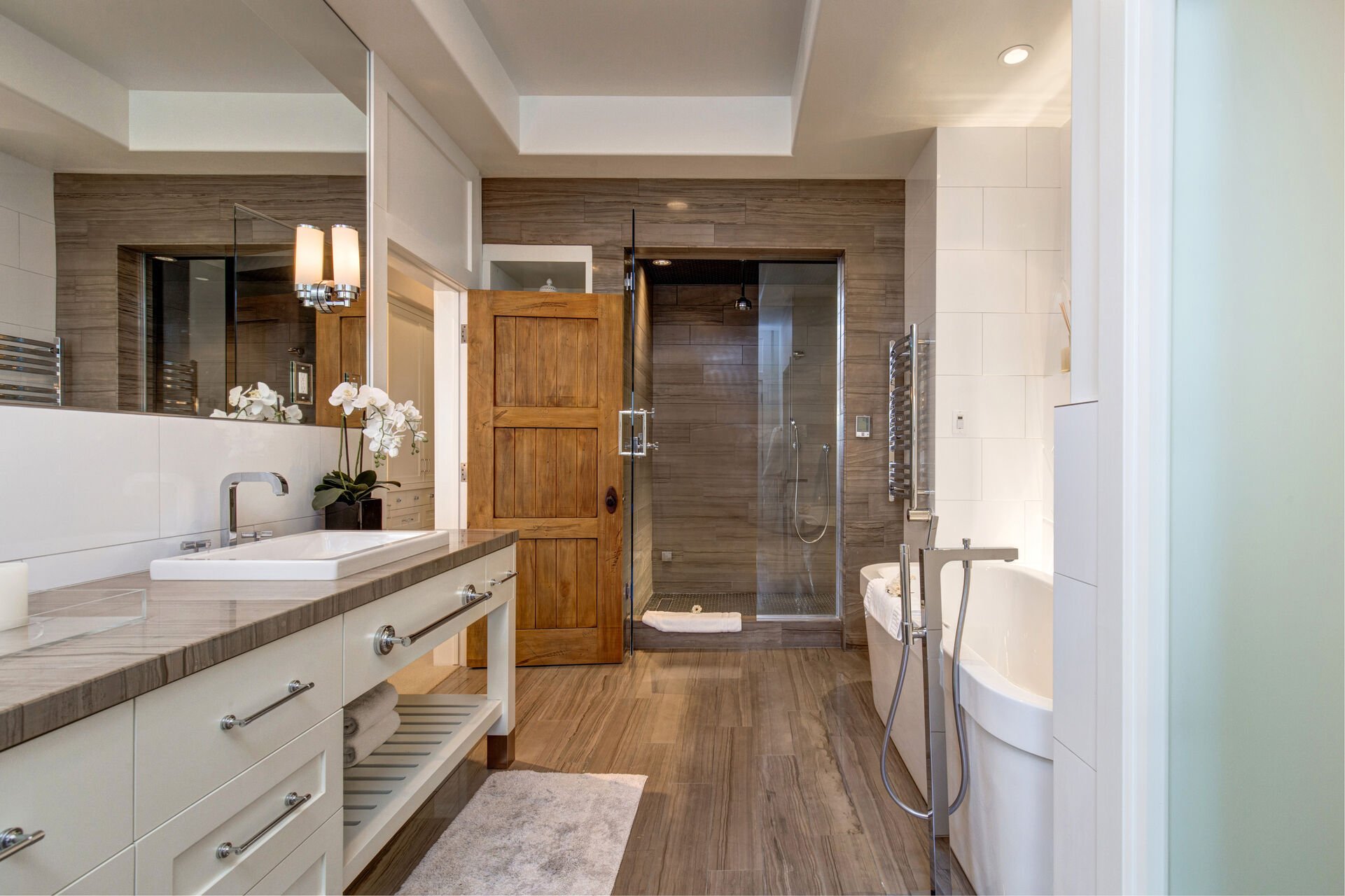 Master Bathroom with double vanity, towel warmers, oversized tile shower, large soaking tub, and hot tub patio access
