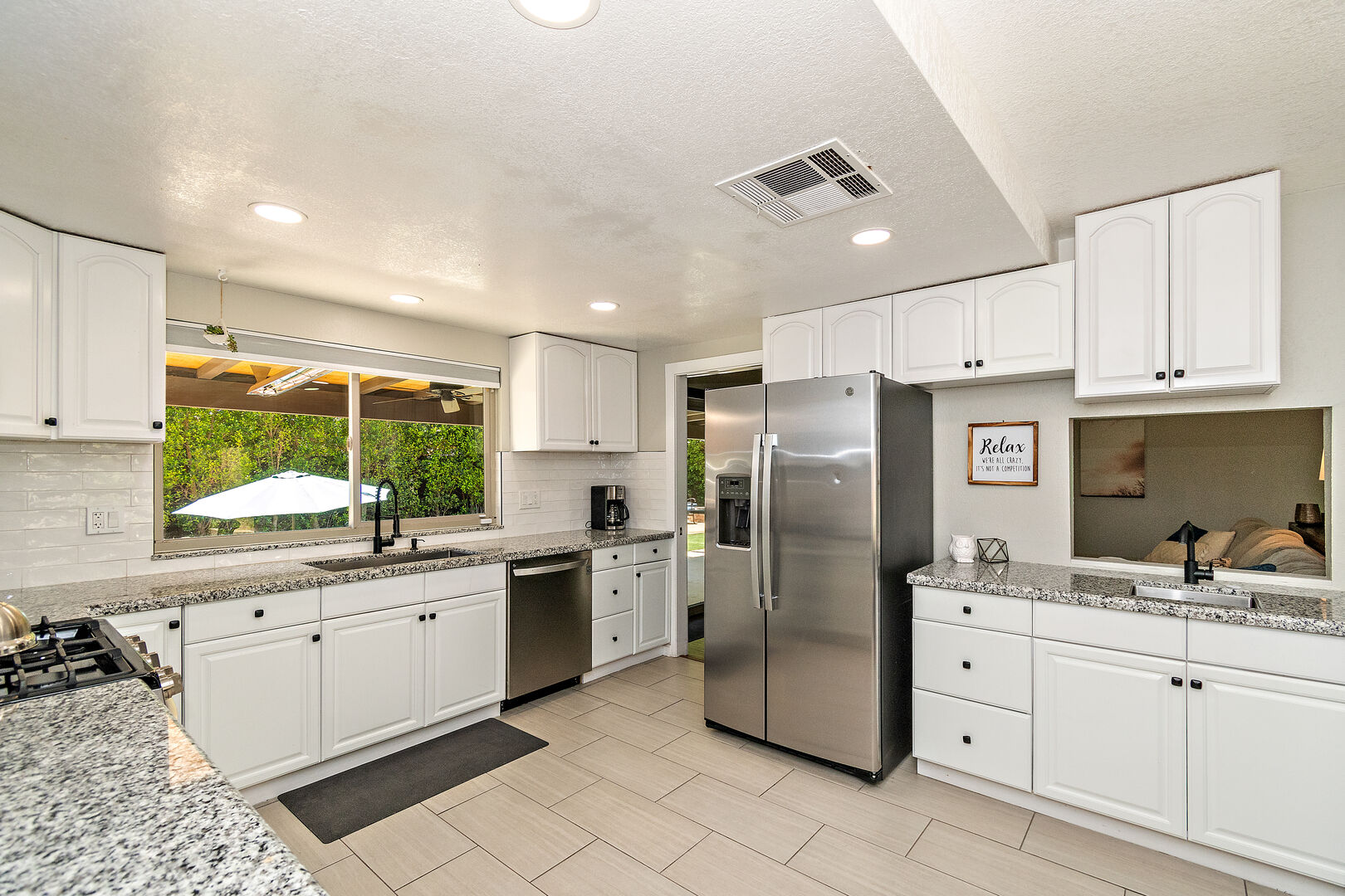 The fully-equipped kitchen features stunning stainless steel appliances such as a GE side-by-side refrigerator with a water and ice dispenser.