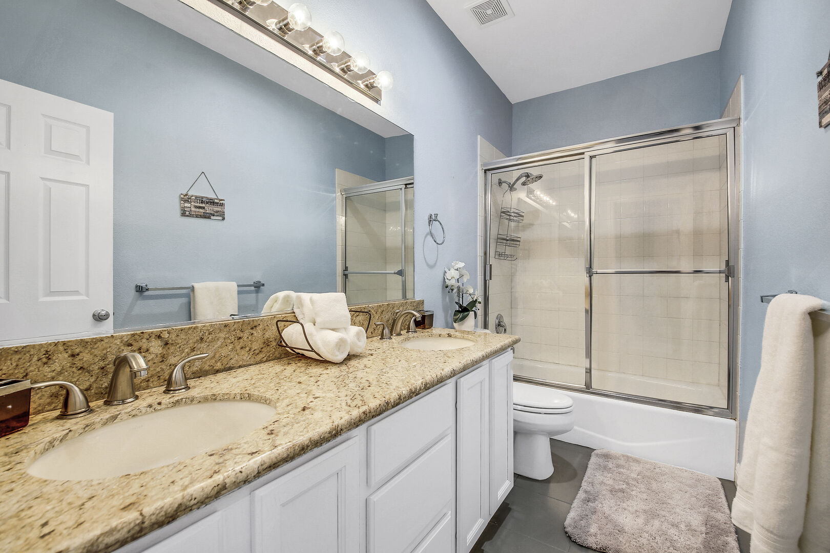The upstairs hallway bathroom is located next to Bedroom 2, features a bathtub and shower combo and double vanity sinks.