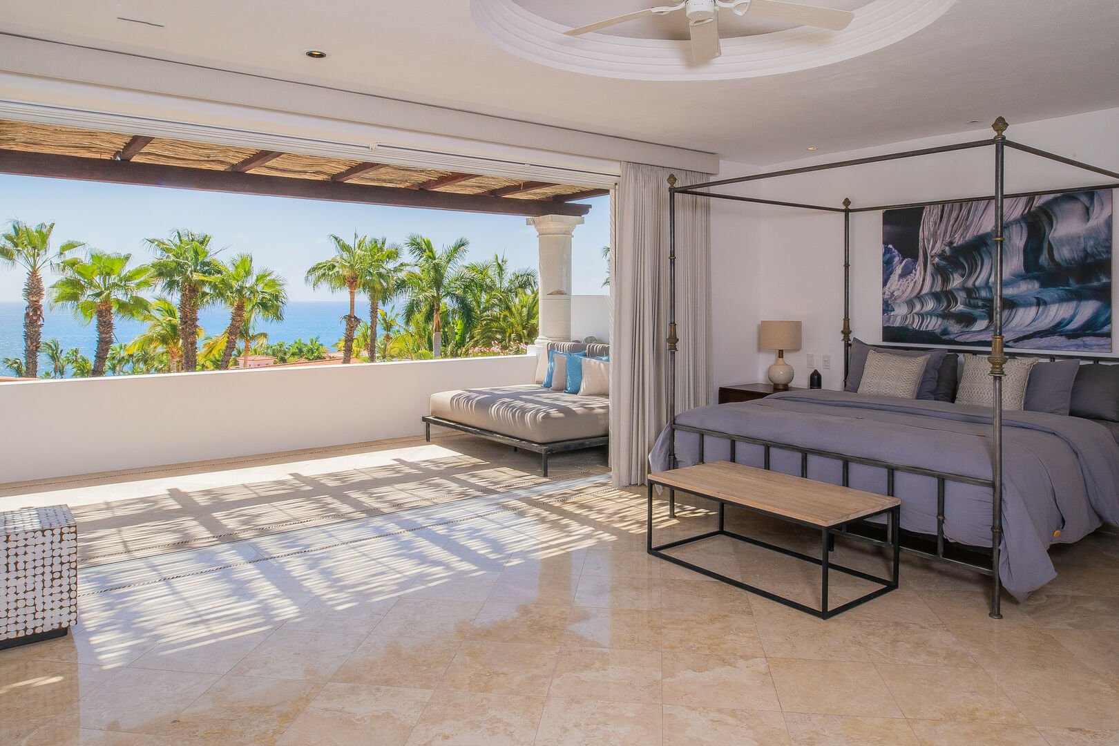 The master bedroom with a view of the ocean from the balcony.