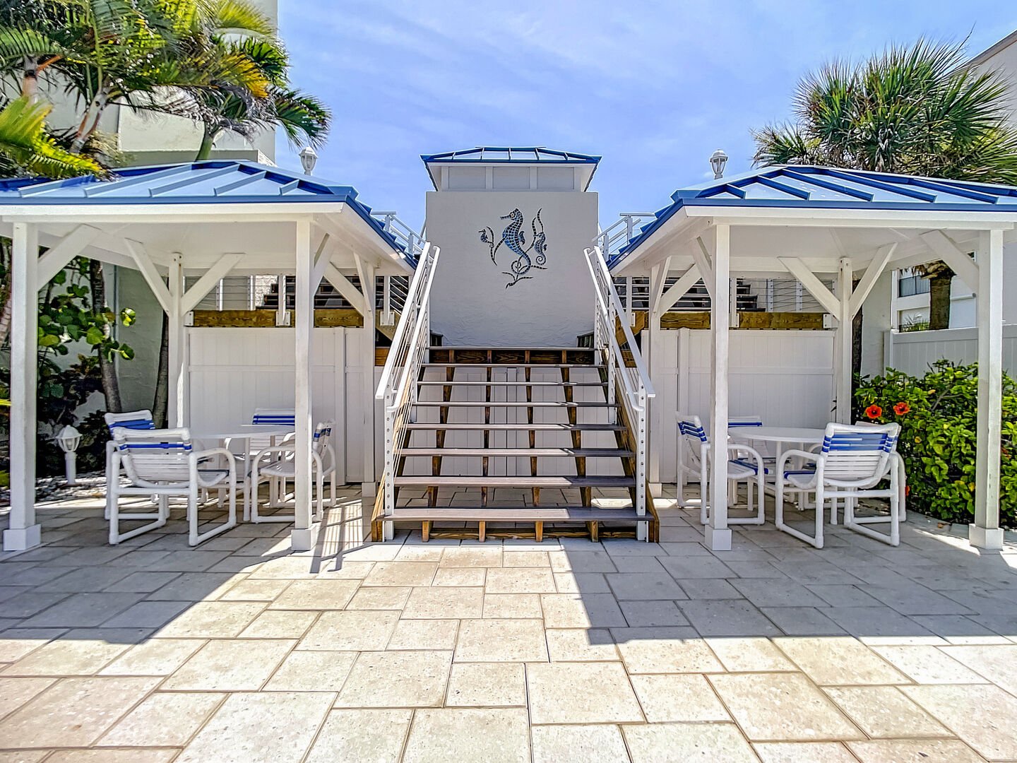 Covered area with tables and chairs by the pool area.
