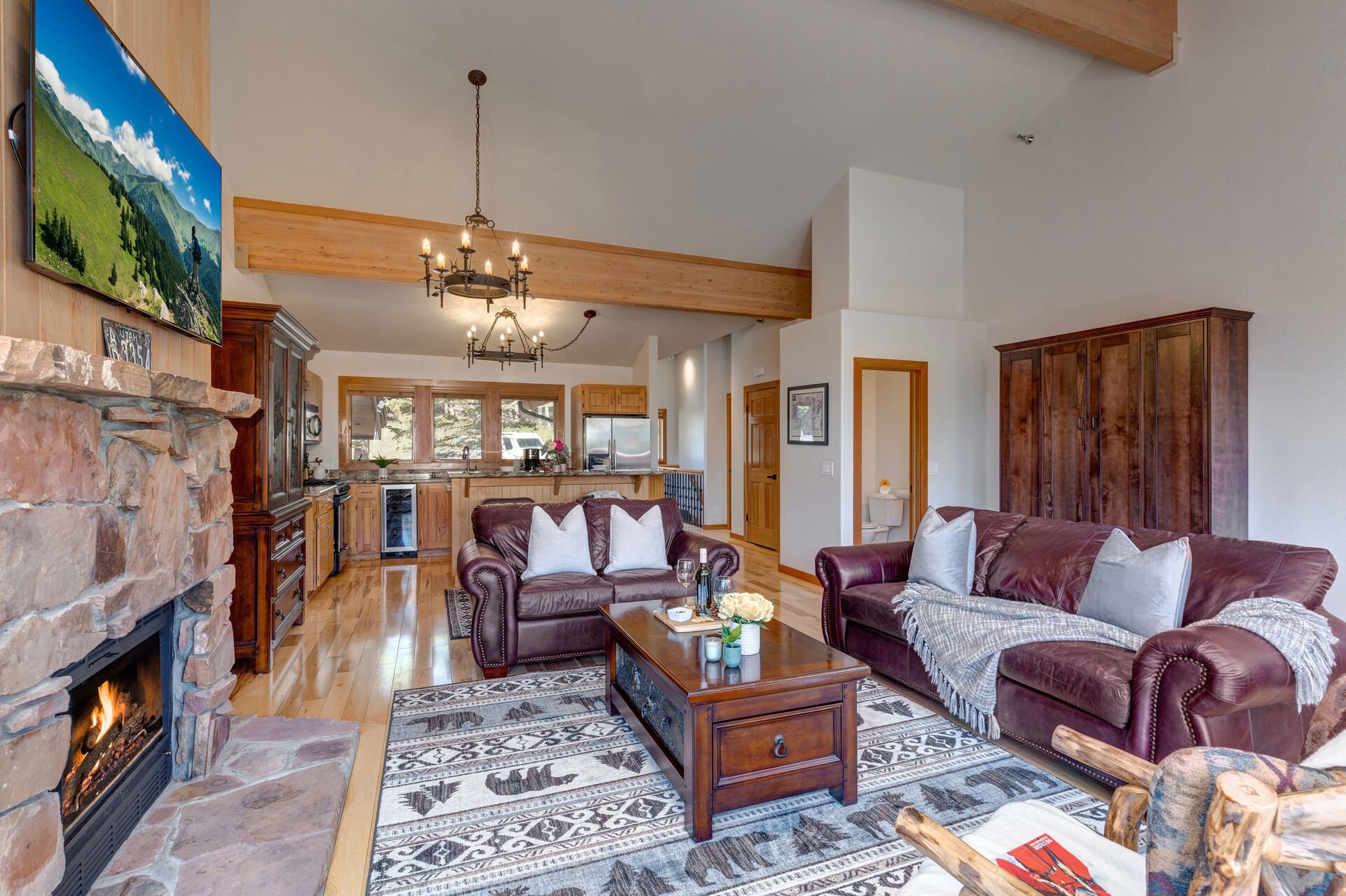 Living Room with plush leather furnishings, gas-assist fireplace, queen-sized Murphy Bed, vaulted ceilings, LG smart tv, and private deck access