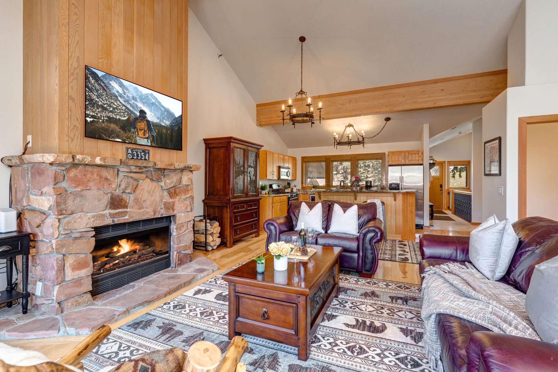 Living Room with plush leather furnishings, gas-assist fireplace, queen-sized Murphy Bed, vaulted ceilings, LG smart tv, and private deck access