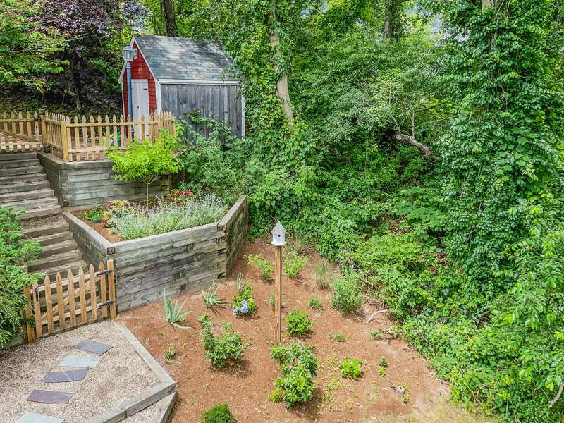 Tiered garden spaces and birdfeeders adorn the side of the home - 132 Horizon Dr - Chatham - Cape Cod