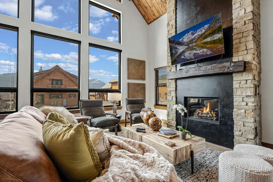 Living room view with cozy 25 foot tall fireplace and 50 inch smart TV