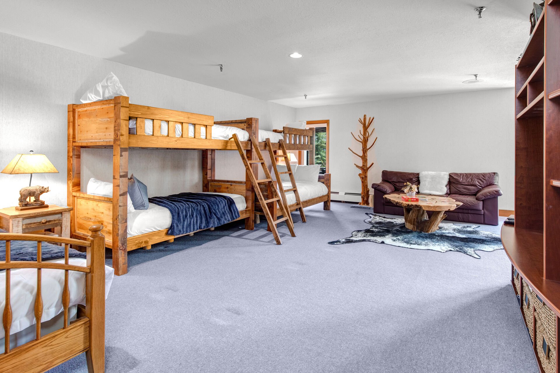 Lower Level Bunk & Game Room with plush leather sofa, twin over twin and twin over full bunk beds, full bed, smart tv, arcade games, ping pong table, private sauna, and full bath access