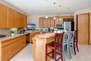 Fully Equipped Kitchen with stainless steel appliances, ample counter-space, TV, and bar seating for four