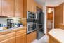 Fully Equipped Kitchen with stainless steel appliances, ample counter-space, TV, and bar seating for four