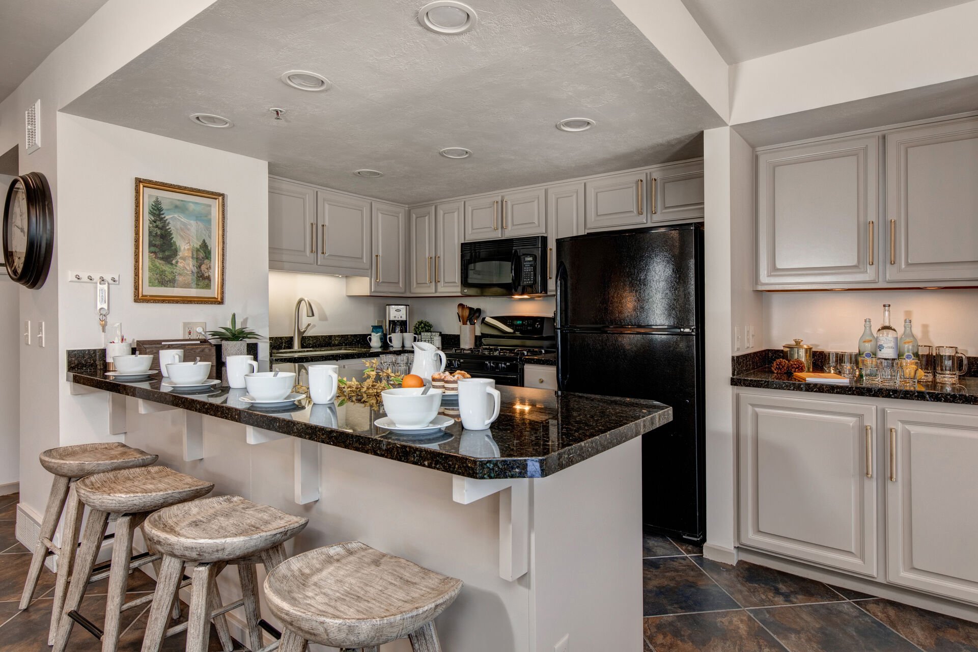 Fully Equipped Kitchen with bar seating for four, beautiful stone countertops, and wet bar