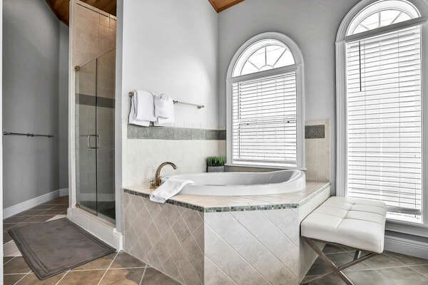 This en suite bathroom offers a beautiful soaking tub and separate shower with balcony access