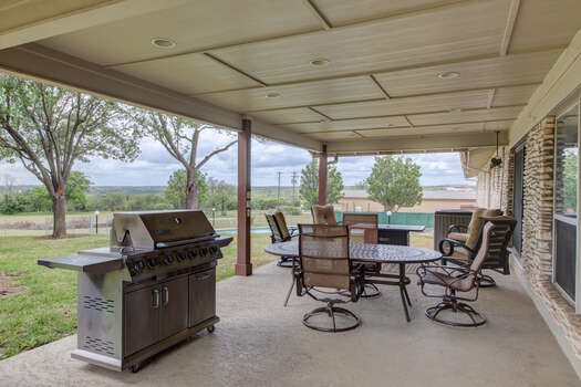 Main level covered patio with a gas BBQ, outdoor dining and fire table