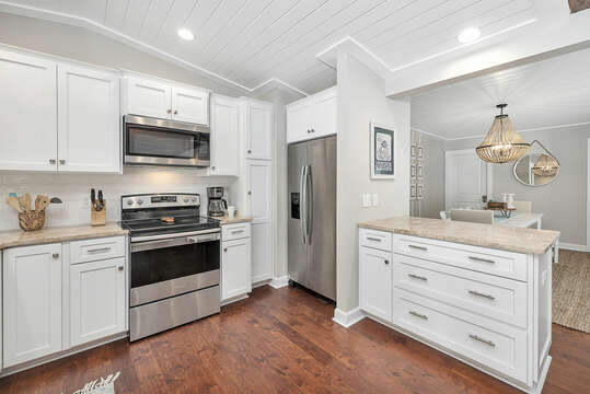Open Kitchen with white cabinets and stainless steel appliances