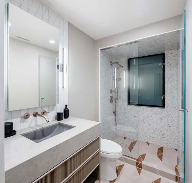 A full bath with large glass shower services this first bedroom.