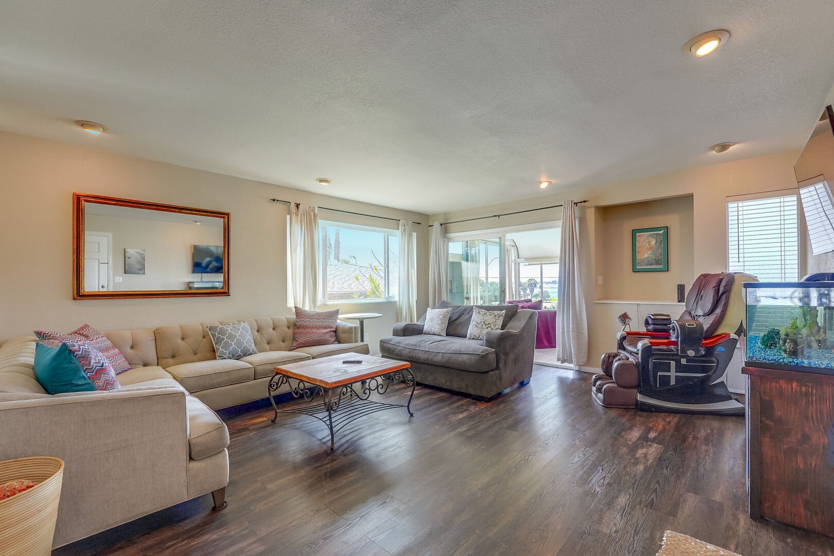 Open living room with massage chair, fish tank and sunroom with Mission Bay views!