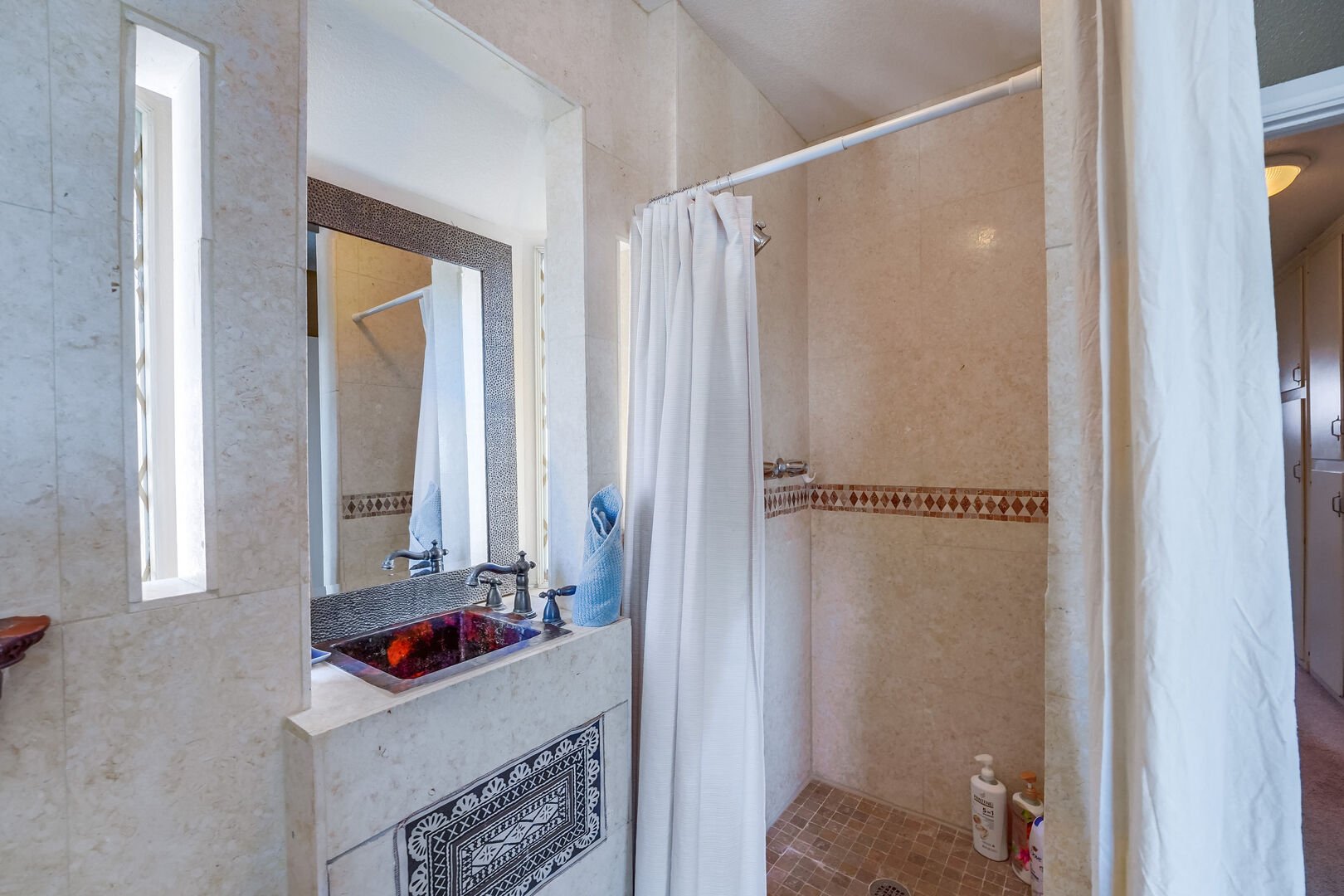 Master bedroom separate walk-in shower and vanity. Please note: the bathroom amenities are not private, there is no dividing door. The bathroom is within the bedroom but there is a curtain divider