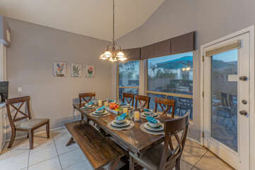 Dining area provides table and bench seating as well as a door to the patio and pool.