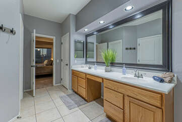 Ensuite primary bath includes dual vanity sinks and large mirror.