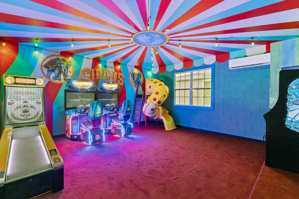 A circus themed games room including skee-ball, dual H2 Overdrive riders, arcade game and twisty slide.