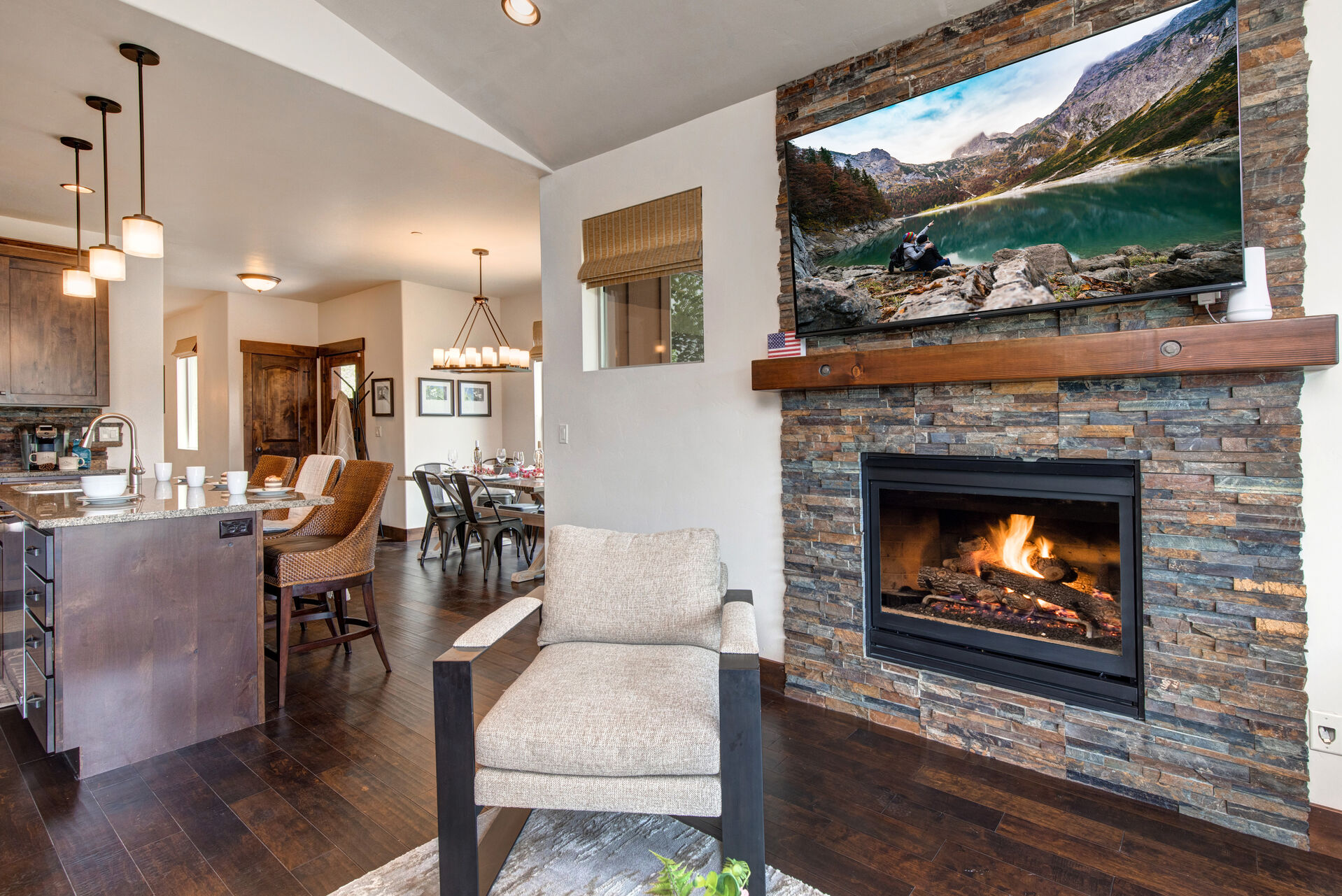 Main Level Living Room with plush sectional, smart tv, gas fireplace, and access to private deck overlooking the surrounding mountain resorts