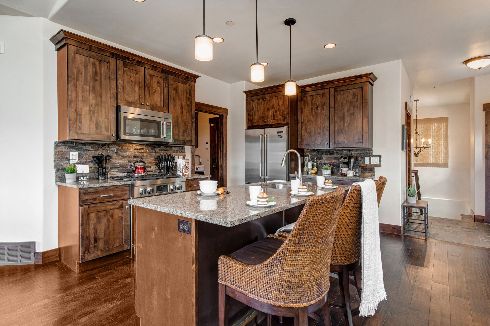 Fully Equipped Kitchen with beautiful stone countertops, modern stainless steel appliances, and island seating for 3