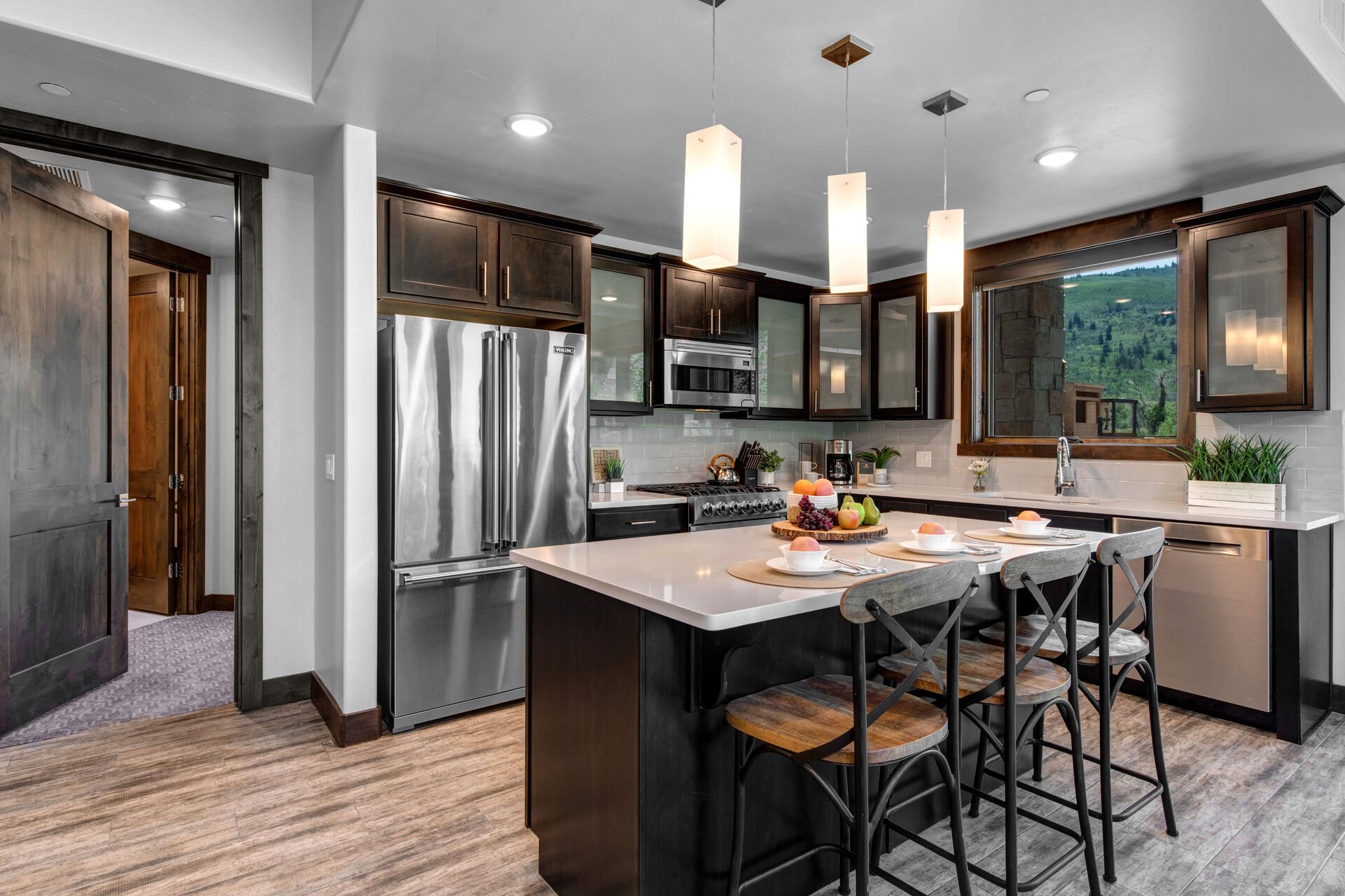 Fully Equipped Kitchen with beautiful stone countertops, stainless steel Viking appliances, and island seating for three