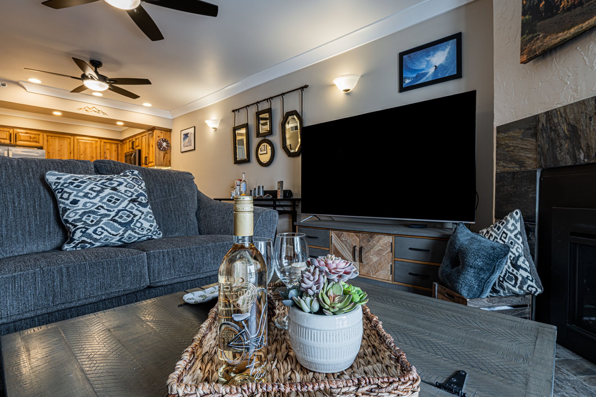 Modern furnishings including sofa sleeper, a cozy gas fireplace, and a 75” Smart TV