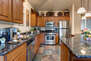Fully Equipped Kitchen with stone countertops, stainless steel appliances, and island seating for three